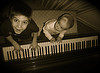 Kids playing piano photograph.